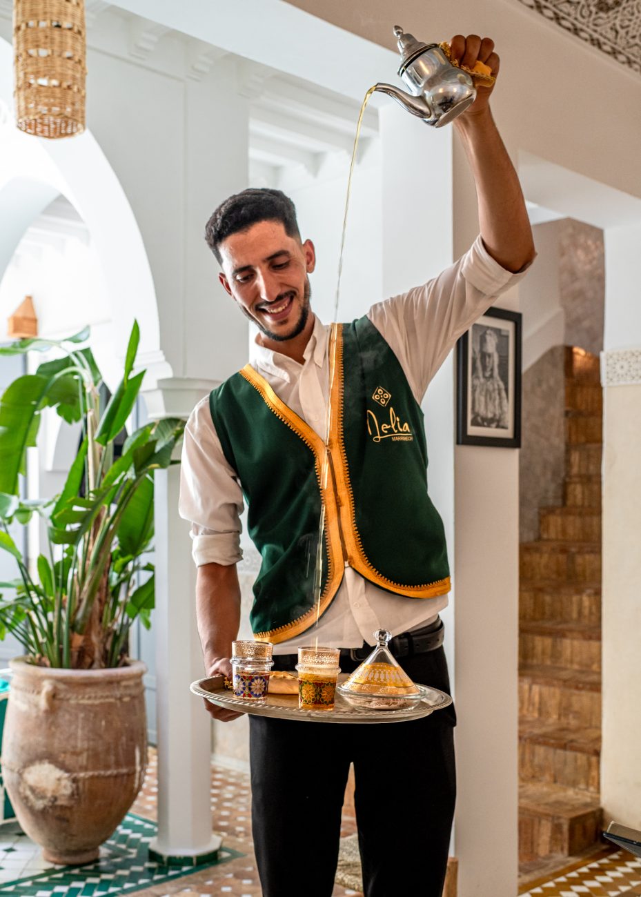 Moroccan man pouring mint tea in Riad Nelia, a traditional riad in the heart of Marrakesh