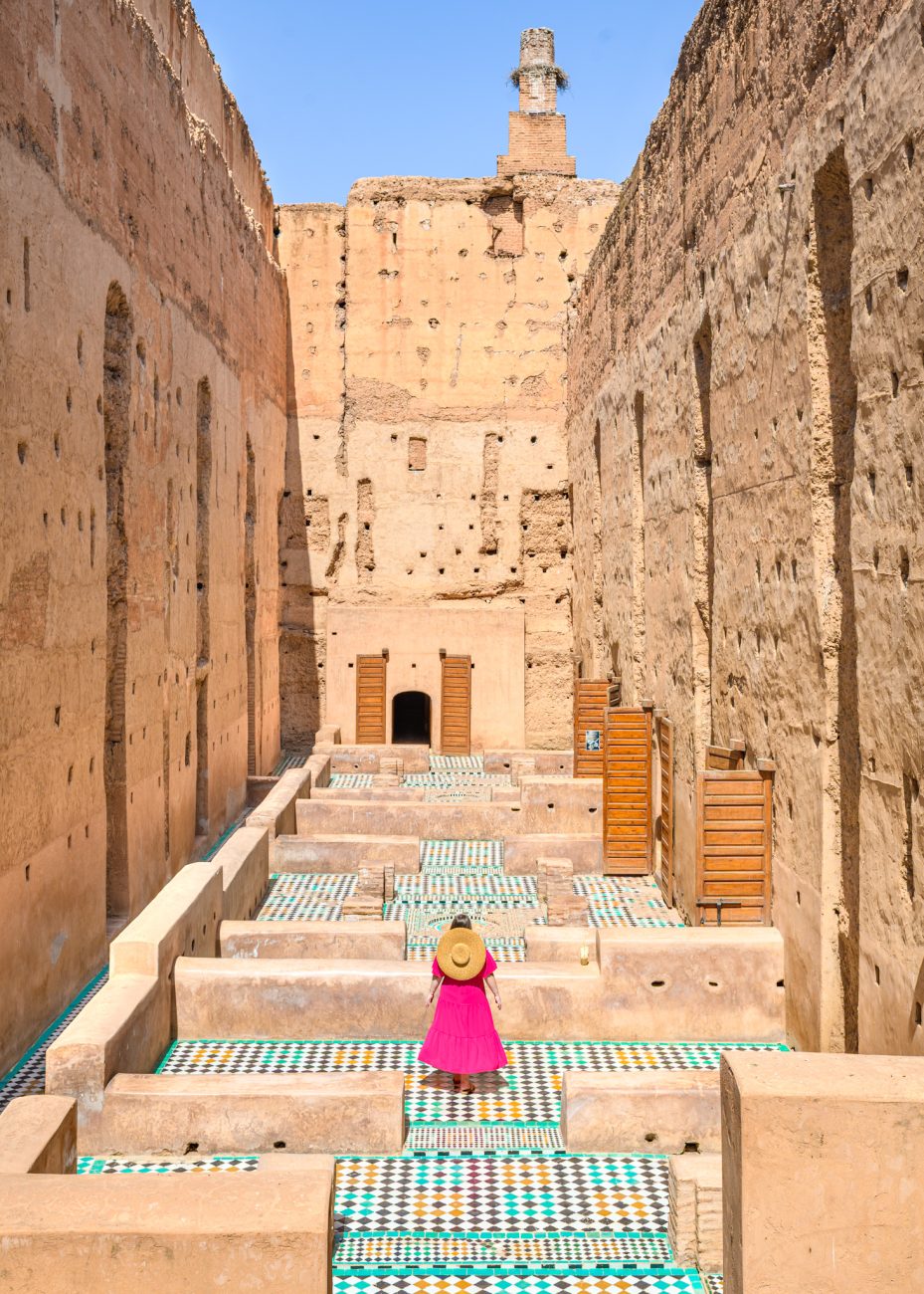 Female tourist in modest outfit walking through a historical Marrakesh attraction — what to wear in Marrakesh as a woman.