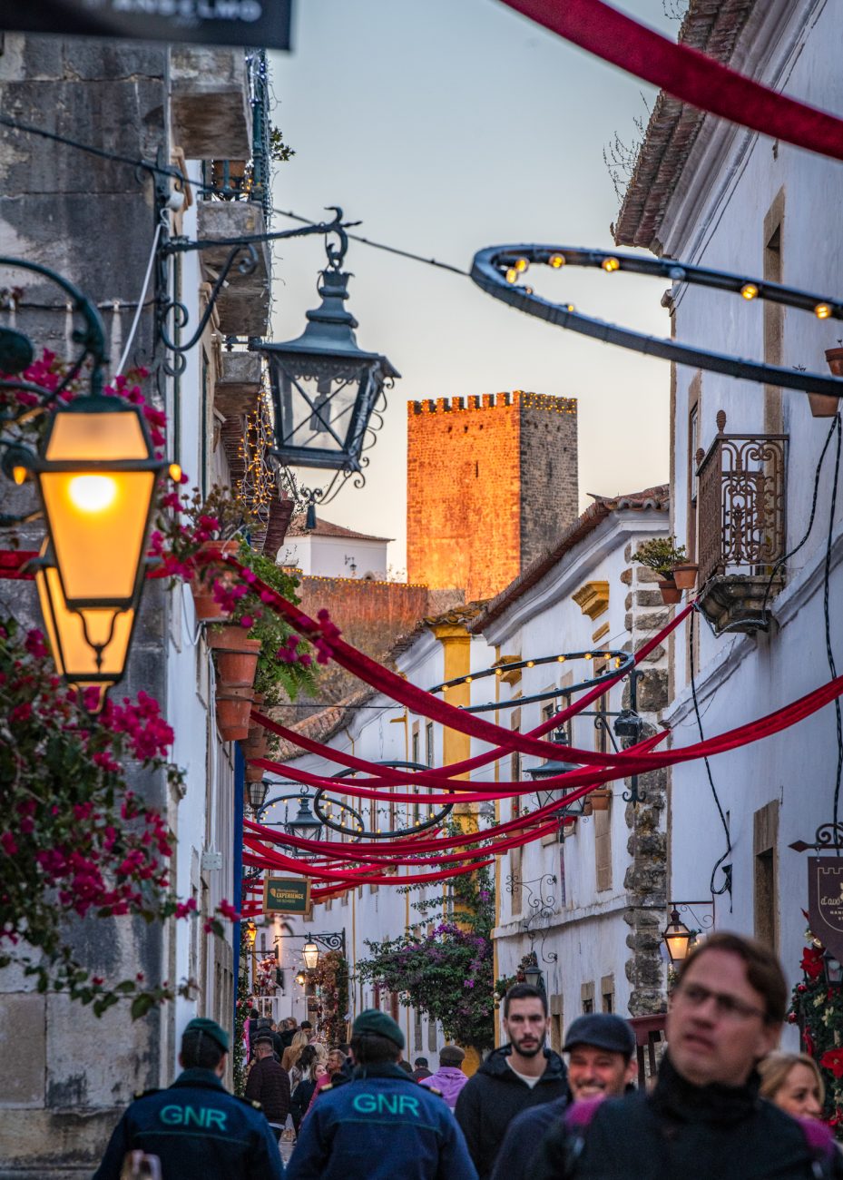 Cobblestone streets of Óbidos glowing with Christmas lights at night
