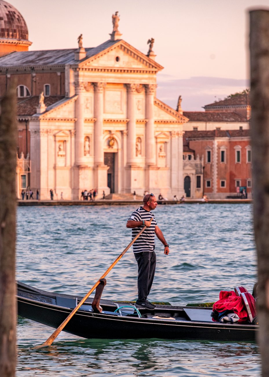 Gondolier steering a traditional black gondola in Venice